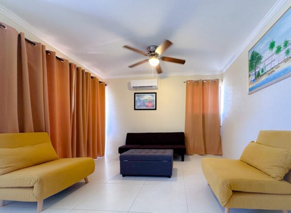 Modern living room with yellow chairs and paintings.